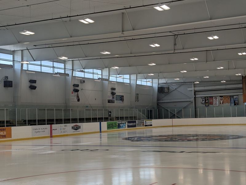 Arena interior with overhead lighting above the ice surface.