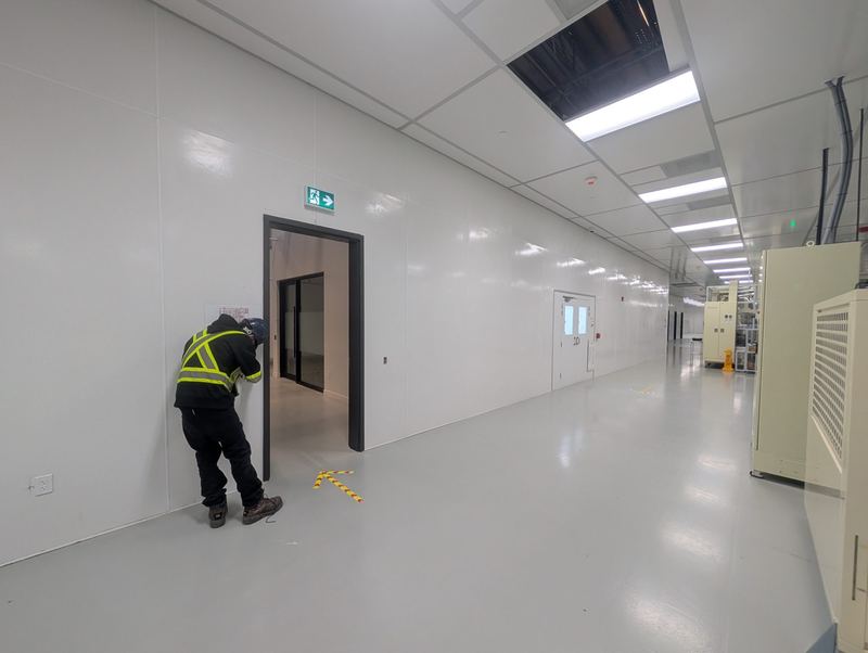 Electrician working in a clean, finished corridor on a commercial project.